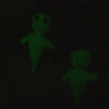Deux fantômes amigurumis photographiés dans l'obscurité, faisant ressortir le fil phosphorescent dans le noir.