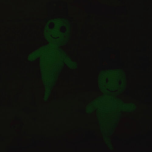 Deux fantômes amigurumis photographiés dans l'obscurité, faisant ressortir le fil phosphorescent dans le noir.