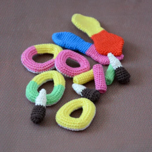 Gros plan sur plusieurs variétés de bonbons crochetés (bouteille de cola, anneaux apollo, frites, langue de chat)